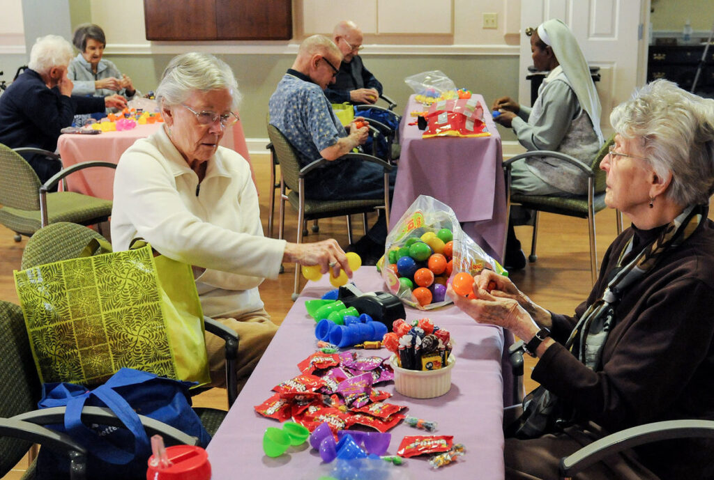 Seniors putting candy and toys in eggs for an event