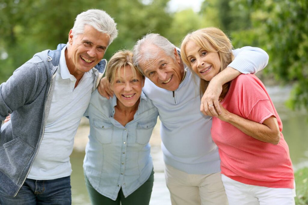 seniors with their arms wrapped around each other smiling at the camera