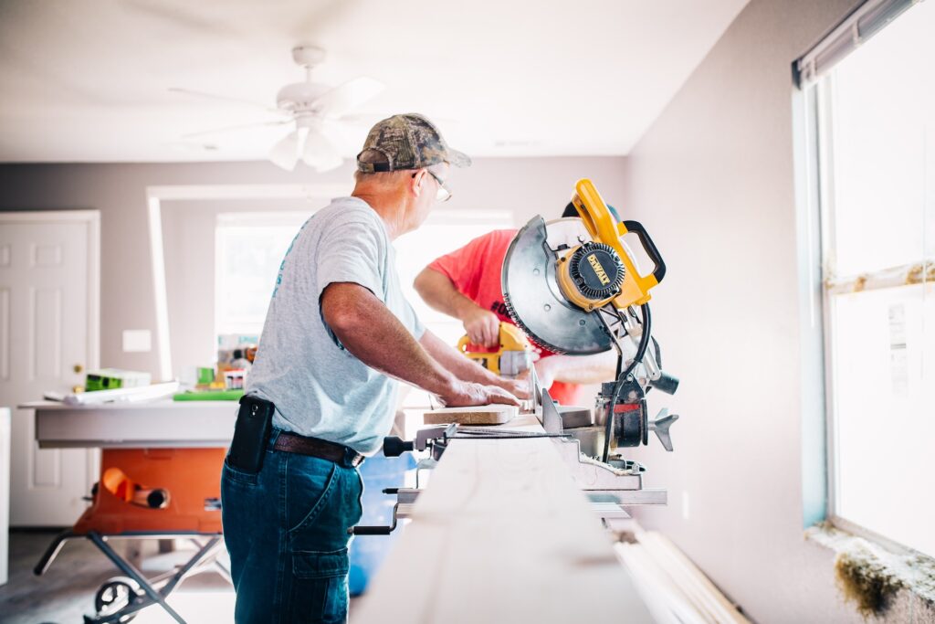 An older man uses a circular saw inside while making home rennovations