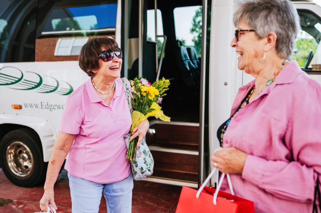 Residents holding flowers in front of shuttle